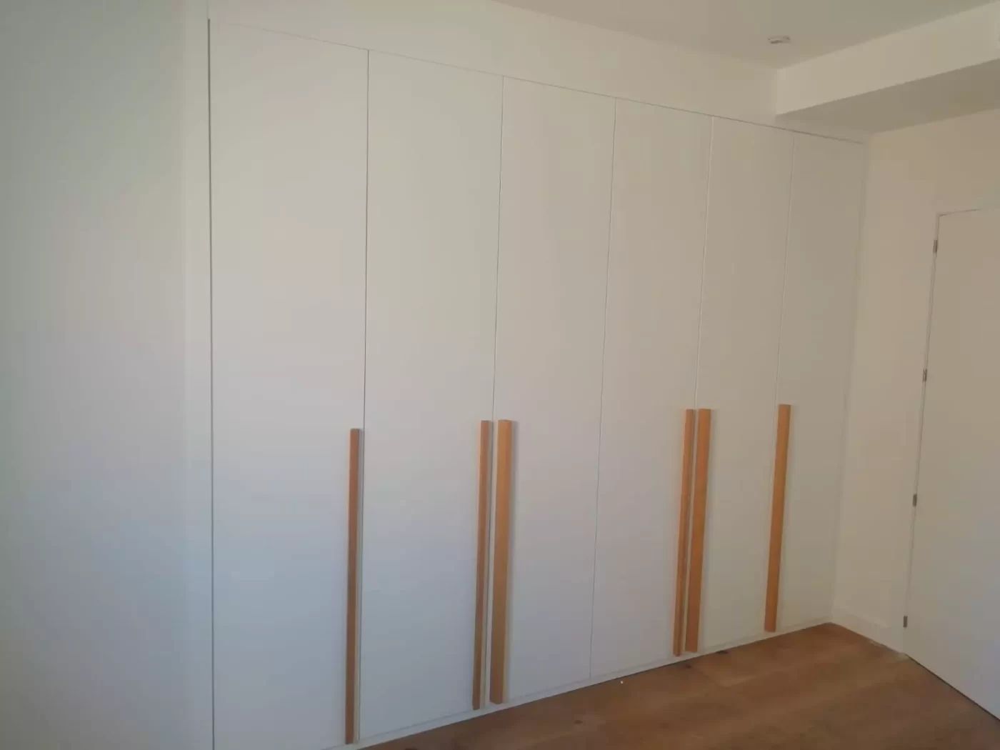 armario abatible blanco con tirador de madera